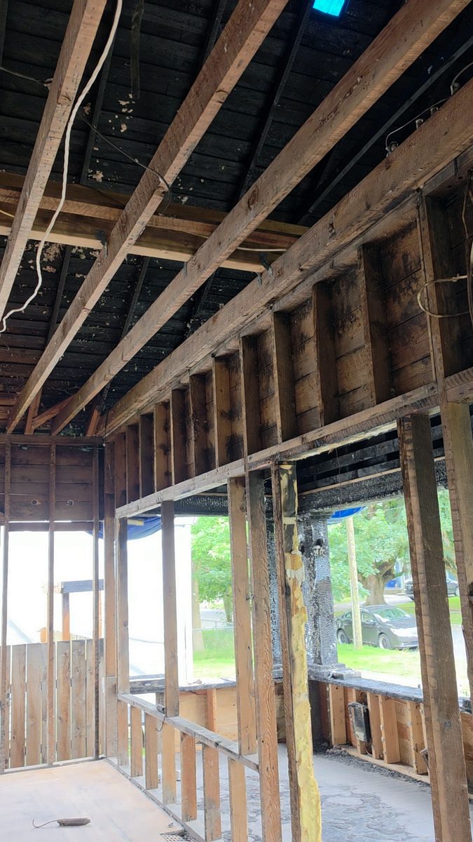 Charred ceiling joists and roof framing with exposed wall studs