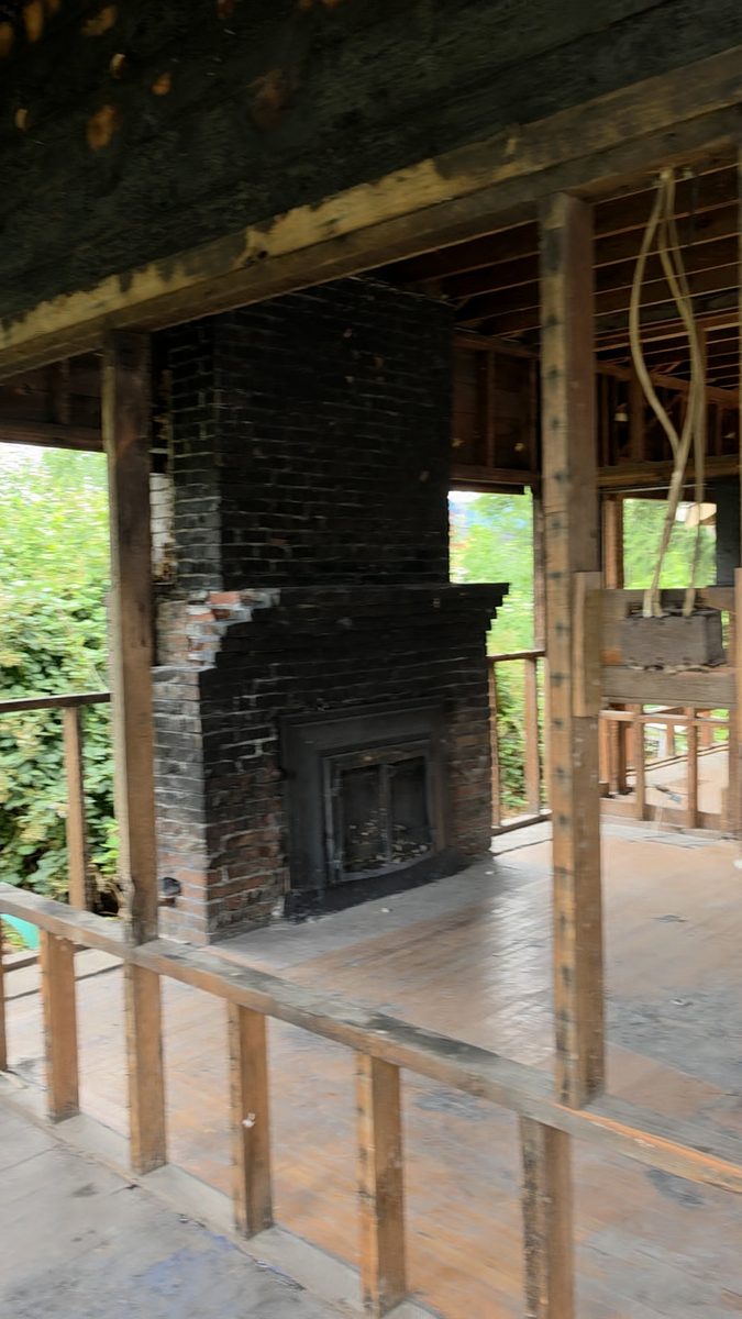 Charred brick fireplace and burned wall framing inside the house